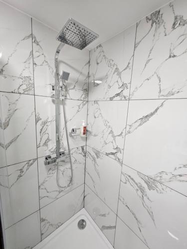 a bathroom with a shower with marble walls at Union House in Stratford-upon-Avon