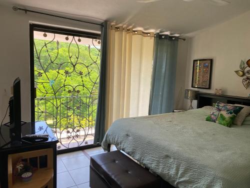 a bedroom with a bed and a window with a view at Casa Palma in Santa Cruz Huatulco