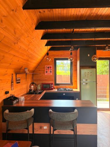 a kitchen with a counter and two chairs in it at Cottage Orion in Sakramulo