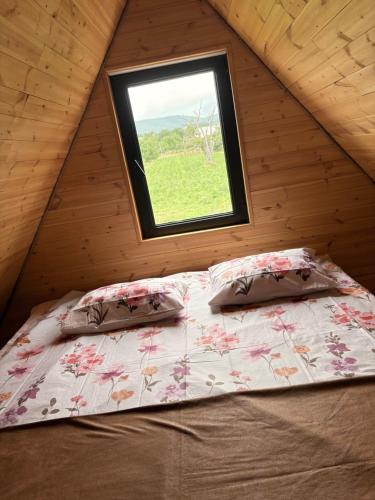 a bed in a room with a window at Cottage Orion in Sakramulo