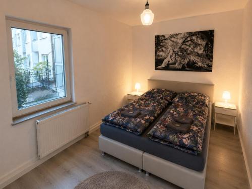 a small bedroom with a bed and a window at Hinterhaus am Schloss Karlsruhe in Karlsruhe