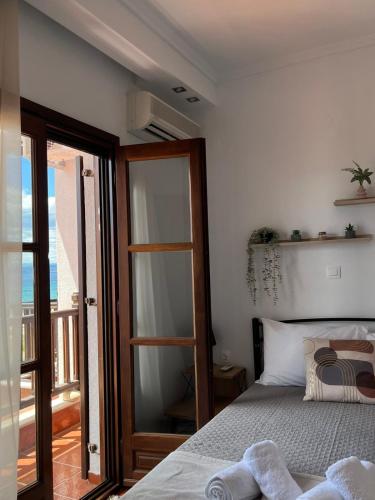 a bedroom with a bed and a door to a balcony at Seaside Athos I in Ouranoupoli