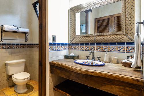 a bathroom with a sink and a toilet and a mirror at Casa Faustina Boutique Hotel in Antigua Guatemala