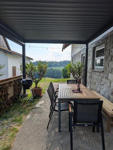 a patio with a table and chairs under a roof at Ferienunterkunft Woidwärts in Schwarzach