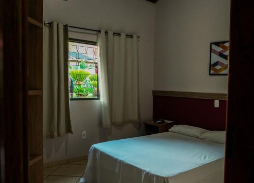 a bedroom with a bed and a window at Hotel Fazenda Haras RD in Olímpia