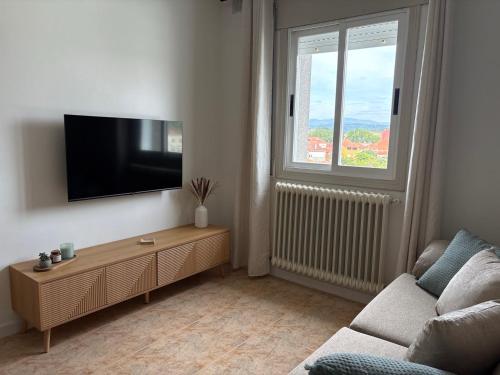 a living room with a couch and a flat screen tv at Alma de Lemos - Apartamento Ribeira Sacra in Monforte de Lemos