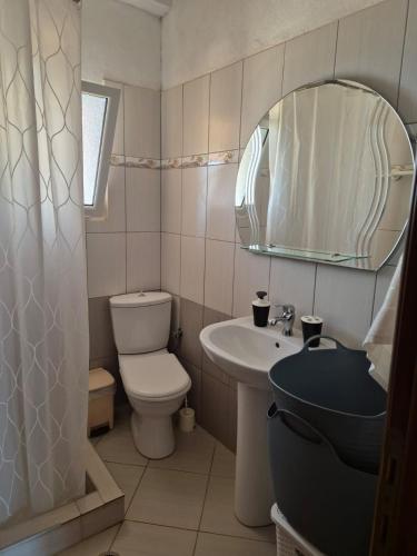 a bathroom with a toilet and a sink and a mirror at Kohil Guest House in Ksamil