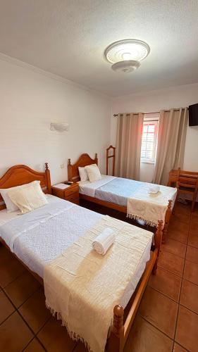 two beds in a hotel room with two beds at Quartos de Vidigueira in Vidigueira