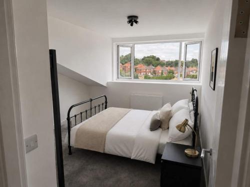 a white bedroom with a bed and a window at Modern Parking Nearby Stores in Swinton