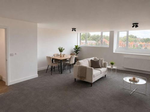 a living room with a couch and a table at Modern Parking Nearby Stores in Swinton