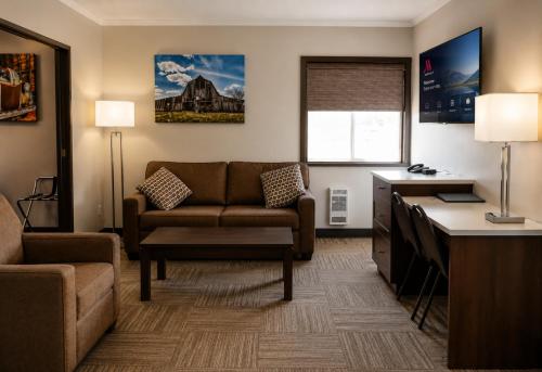 a living room with a couch and a desk at Homestead Inn & Suites in Vanderhoof