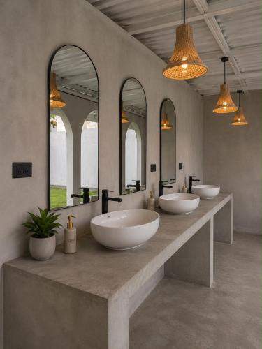 a bathroom with three sinks and three mirrors at Curve Ahangama in Ahangama