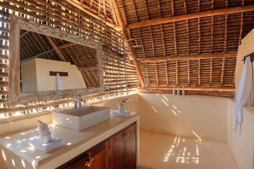 a bathroom with a sink and a mirror at Tulia House Lamu in Lamu