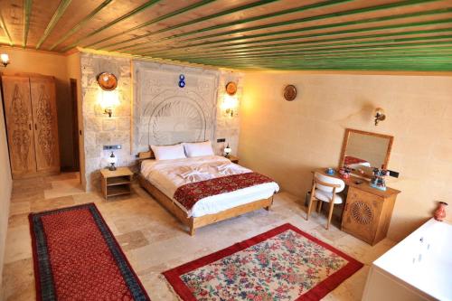 a bedroom with a bed and a table and a mirror at Süleyman Cappadocia - Hot Air Balloon View in Göreme