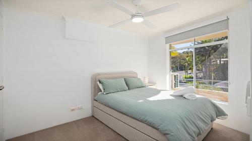 a white bedroom with a bed and a window at Quayside in Nambucca Heads