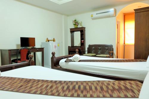 a hotel room with two beds and a refrigerator at Siam House Interplace in Lop Buri