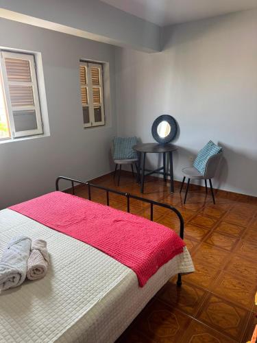 a bedroom with a bed and a table and chairs at S Vicente Live in Mindelo