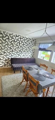 a dining room with a table and a couch at Apartament in Sykkylven