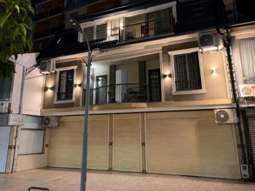a building with a garage door and a balcony at Gold City Hotel by Erebara in Debar