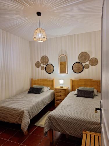 a bedroom with two beds and a chandelier at Casa 3 Chamines in Vila Alva