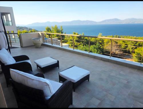 a balcony with couches and a view of the ocean at Azure Theologos Villa in Theologos