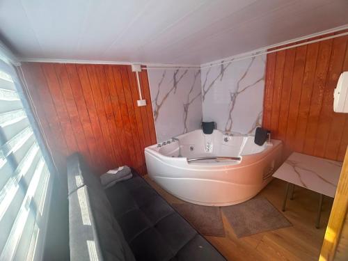 a bathroom with a white tub in a room at Dyl Tiny House con Jacuzzi in Puerto Montt