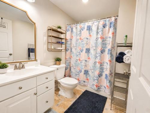 a bathroom with a toilet and a shower curtain at Spacious Studio by the Woods in Laurel