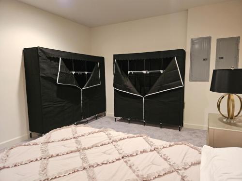 a bedroom with two large beds with black covers at Spacious Studio by the Woods in Laurel