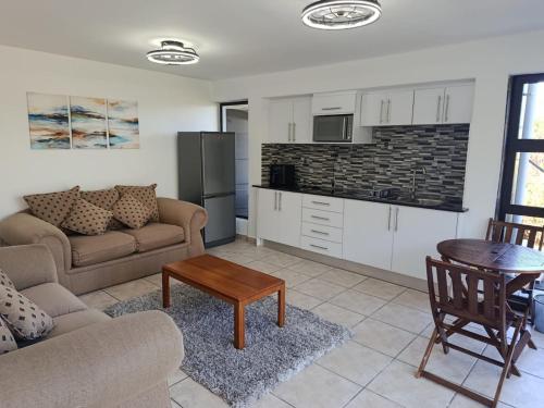 a living room with a couch and a table at The Tee Box in Southbroom