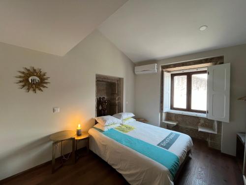 a bedroom with a large bed and a window at Risoturismo-Solar de São João - Guest House - in Almeida