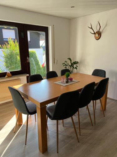 a dining room with a wooden table and chairs at Tannennest in Seewald