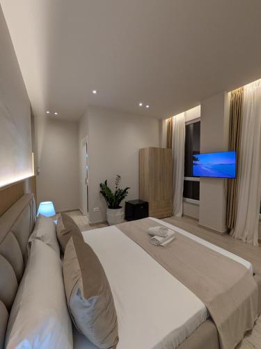 a large bedroom with a large bed and a flat screen tv at Todo Luxury Suites in Durrës