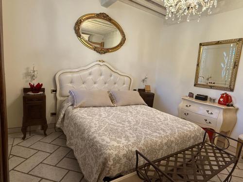 a bedroom with a large bed and a mirror at 27 Arte Bientina in Bientina