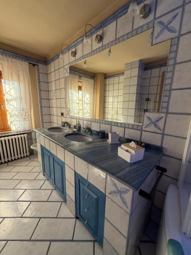 a bathroom with two sinks and a large mirror at 27 Arte Bientina in Bientina