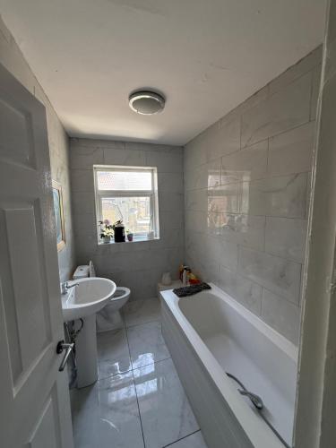 a white bathroom with a tub and a sink at 10 wyeverne road in Cardiff