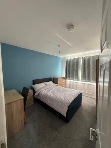 a bedroom with a bed and a blue wall at 10 wyeverne road in Cardiff
