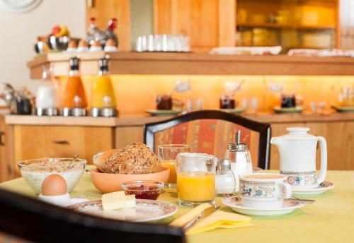 a table with a breakfast of eggs bread and orange juice at Hotel Käferstein garni in Nürnberg