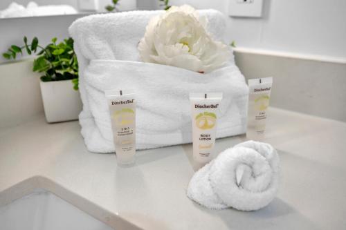 a bathroom counter with towels and a towel roll and a flower at The Sanctuary King studio in Miami