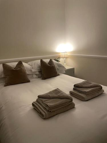 a white bed with two towels on top of it at Belle-Vue in Truro