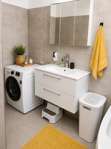 a bathroom with a washing machine and a sink at Steffi Apartment in Balş