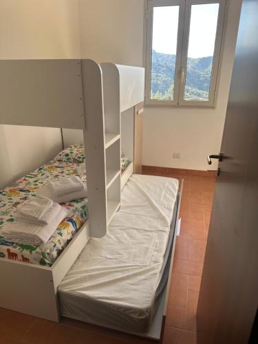 a white bunk bed in a room with a window at Villa Luca e Vale in Graniti