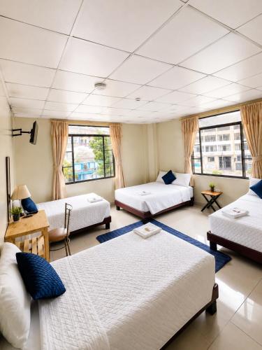 a large room with two beds and a couch at Hostal Marín Central - Quito in Quito