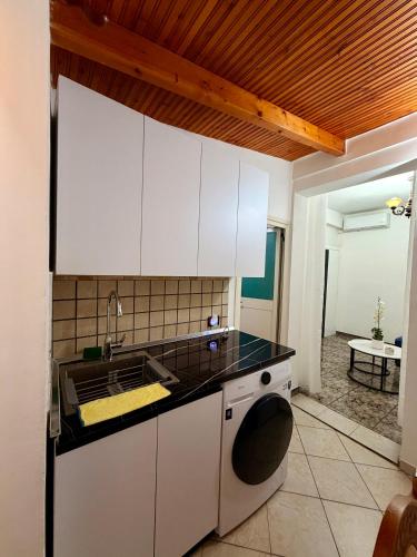 a kitchen with a sink and a washing machine at Green Door House in Vlorë