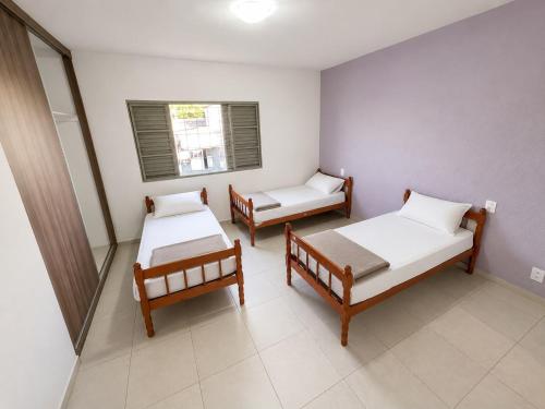 a room with three beds and a window at Morada 360 Casa Inteira para até 09 Pessoas in Sumaré