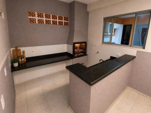 a kitchen with a counter and a fireplace at Morada 360 Casa Inteira para até 09 Pessoas in Sumaré
