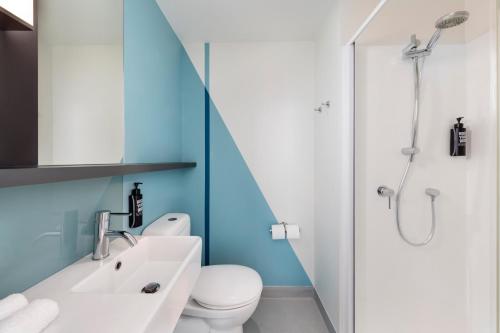a bathroom with a sink and a toilet and a shower at ibis Budget Auckland Airport in Auckland