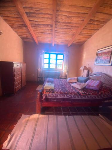 a bedroom with a large bed and a window at Hostal sabana Tilcara in Tilcara