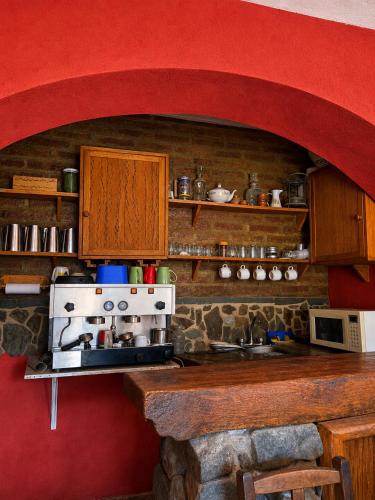 a kitchen with a stove and a brick wall at Hostal sabana Tilcara in Tilcara