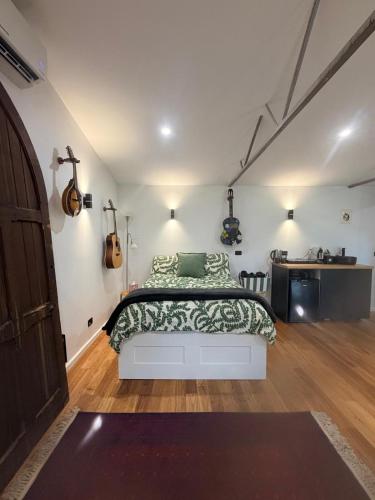 a bedroom with a bed and guitars on the wall at Mustang Studios in Canberra