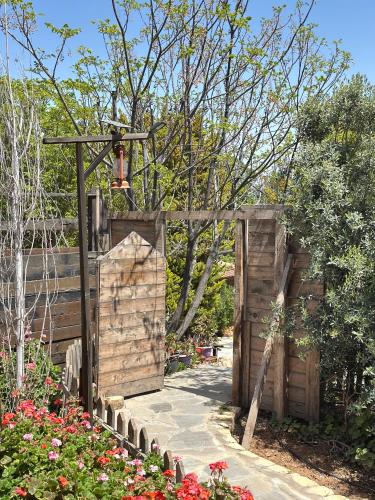 a wooden gate in a garden with flowers at Fashet alsalt-فشة السلط in Al Salt